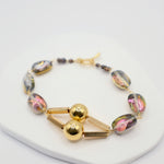 Bracelet with gold and multicoloured beads on a white background