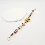 Bracelet with multicoloured beads and gold clasp on a white background