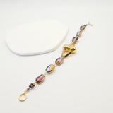 Bracelet with multicoloured beads and gold clasp on a white background