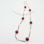 Necklace with burgundy beads and white pearls on a white background