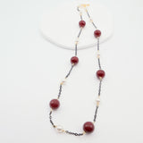 Necklace with burgundy beads and white pearls on a white background