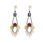 Pair of earrings with white pearls, dark chain and gold discs on a white background