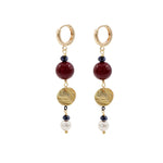 Pair of gold hoop earrings with burgundy shell pearls, gold discs , and pearl beads on a white background