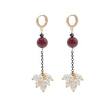 Pair of earrings with burgundy beads and pearl-like elements on a white background