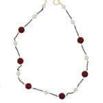 Necklace with burgundy and white beads on a white background