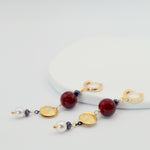 Earrings with gold, burgindy, and pearl beads on a white background