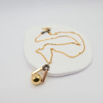 Gold necklace with a pendant on a white background
