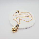 Gold necklace with a pendant on a white background
