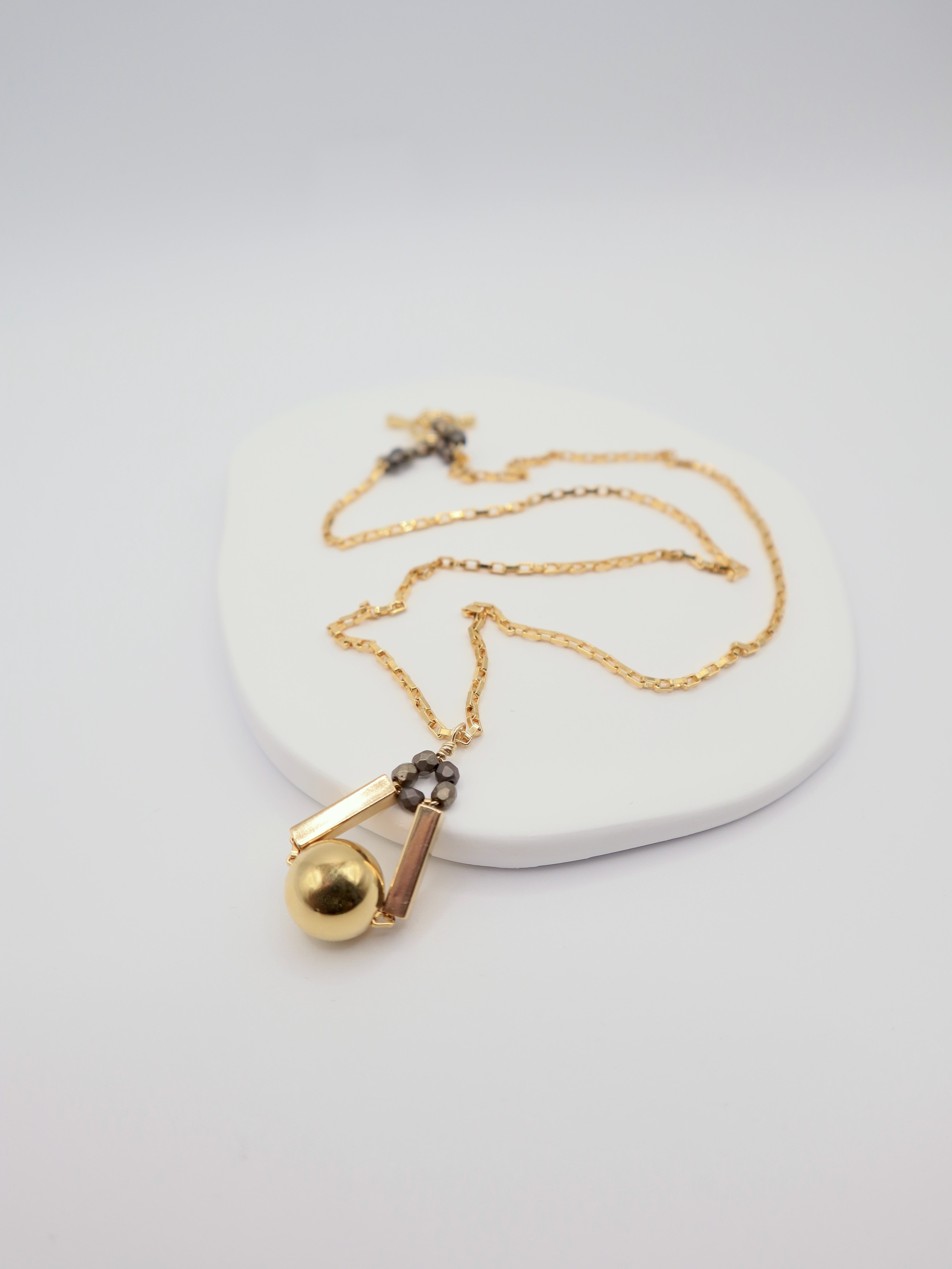 Gold necklace with a pendant on a white background