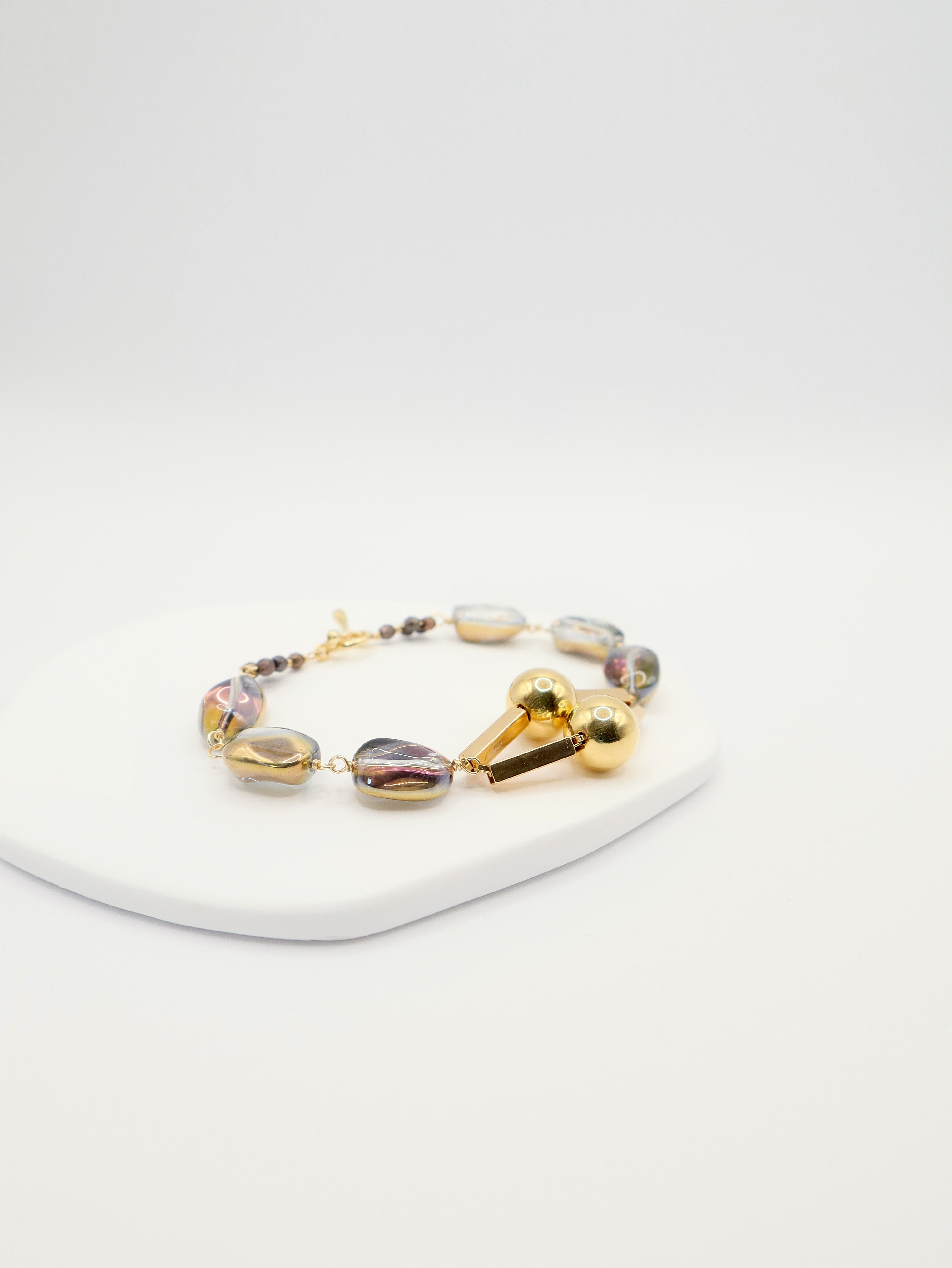 Translucent glass bead bracelet with gold geometric centrepiece