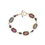 Bracelet with colorful beads and gold clasp on a white background