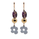 Pair of earrings with gold beads and flower-shaped charms on a white background