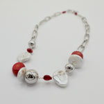 Necklace with red coral, freshwater pearls and silver beads on a white background