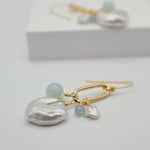 Pearl and aquamarine earrings on a white background