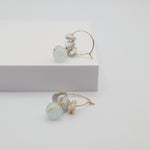 Pair of earrings with aquamarine beads and freshwater pearls on a white background