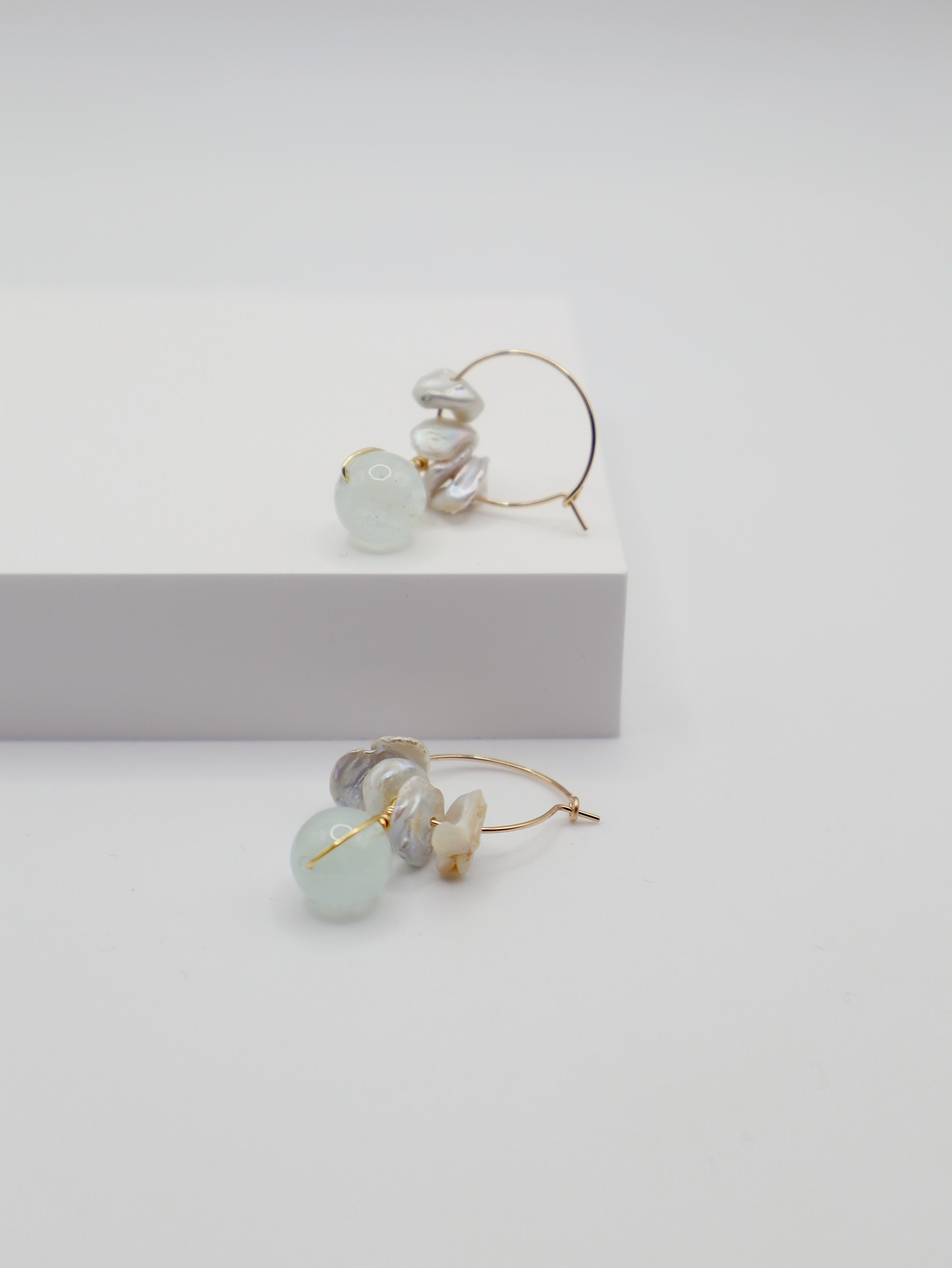Pair of earrings with aquamarine beads and freshwater pearls on a white background