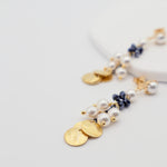 Delicate gold and pearl earrings on a light gray background