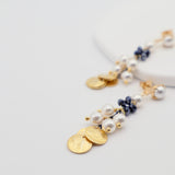 Delicate gold and pearl earrings on a light gray background