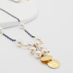 Necklace with pearls and gold pendants on a white background