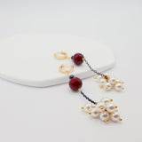 Pair of earrings with pearls and burgundy beads on a white background